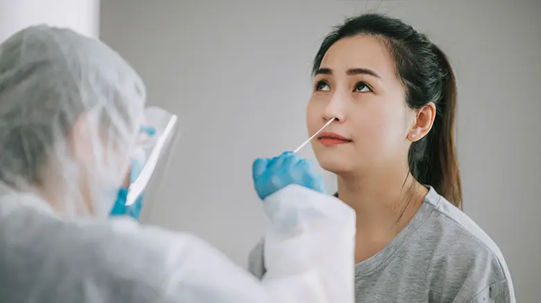 穿戴 PPE（个人防护装备）的亚洲华人女医生正在患者冠状病毒检测中采集鼻拭子。穿着防护服的医务人员正在采集拭子以进行冠状病毒检测，可能已感染的女士正在进行快速诊断检测，穿戴 PPE（个人防护装备）的亚洲华人女医生正在患者冠状病毒检测中采集咽拭子。穿着防护服的医务人员正在采集拭子以进行冠状病毒检测，可能已感染的女士正在进行 PCR 设备检测图库照片
